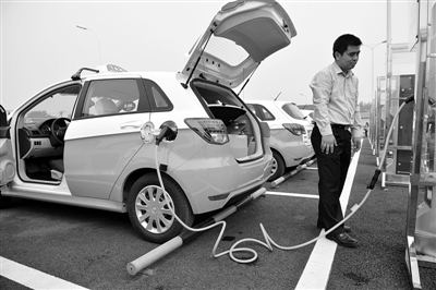 2013年9月28日，全国最大的电动出租车充电站在通州投入使用，出租车司机正在充电站给车充电。新京报资料图片 吴江 摄